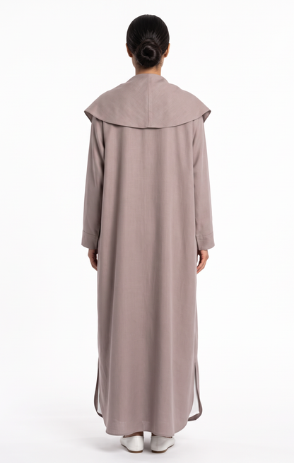 Back view of women's taupe trench abaya featuring storm-flap collar overlay and side hem slits