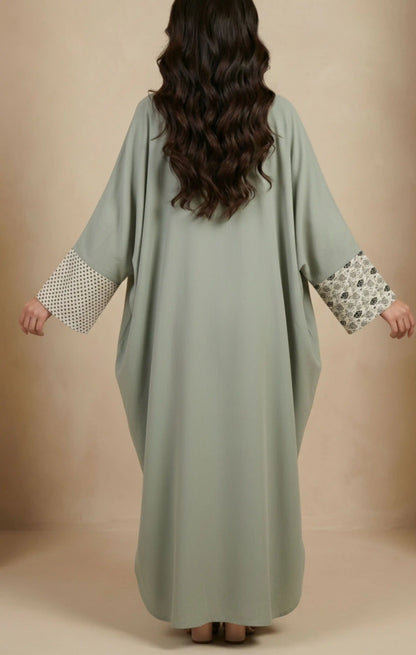 Two-piece modest abaya with a patterned cotton-silk front panel featuring vertical detailing, worn over a solid-color inner dress.